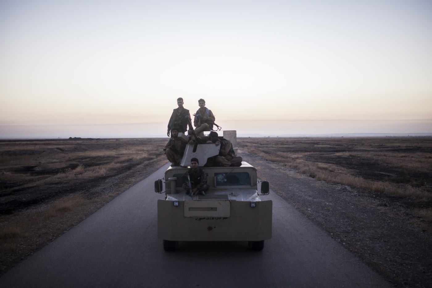 Peshmergas militiamen lying exhausted on a tank minutes after the Islamic State attack. Tuzkhurmatu, Kurdistan, Iraq. June 20, 2017