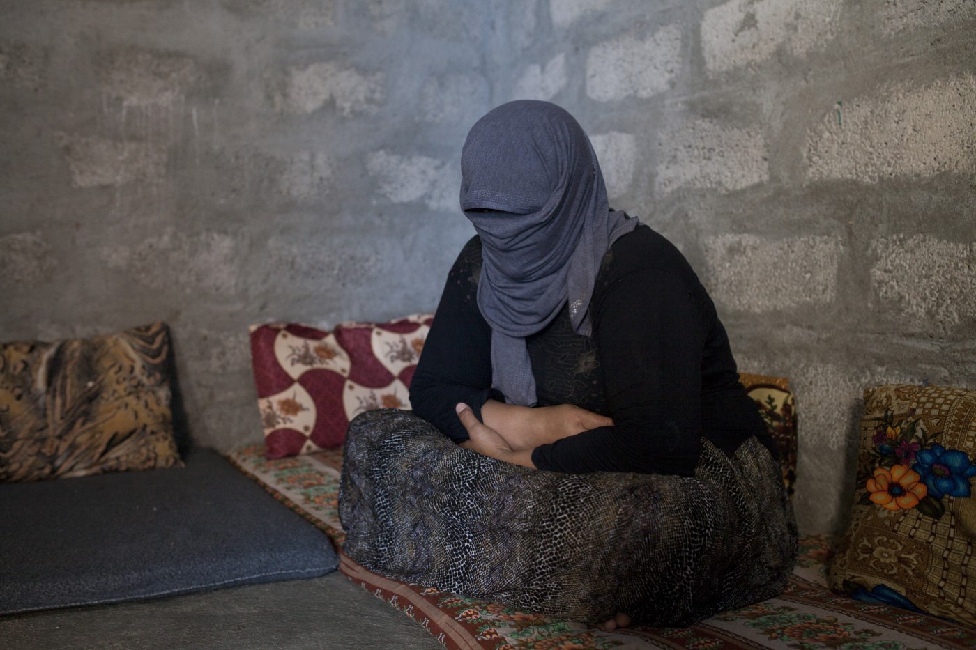 Sayran K. (40). Dona Yazidí. Segrestada per l’EI el 3 d’agost de 2014 a Shangal, es tapa el rostre per por a ser descoberta. Obligada a convertir-se a l’islam. La seva família va poder-la rescatar de l’EI per 20.000 dòlars. Tres anys més tard, no sabia res de les seves sis filles i dos fills encara en mans de l’Estat Islàmic. Duhok, Kurdistan, Iraq. 4 de juliol de 2017