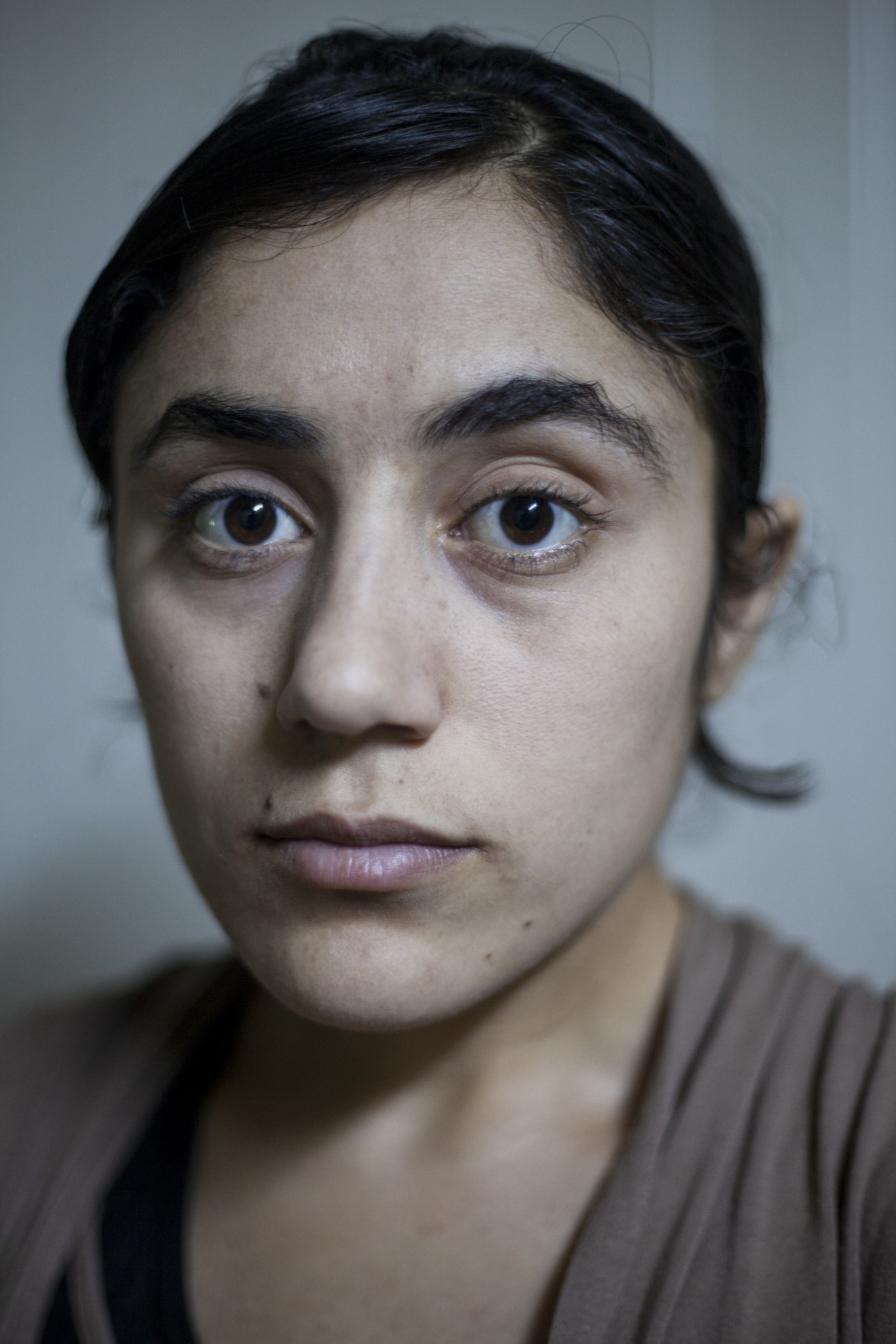 Bafrin Shivan. Yazidi Woman (19). Bafrin was kidnapped on the day Daesh occupied Shangal (Iraq) in 2014. She was a16 year-old virgin. Several men from her family were murdered: two brothers, three cousins and two uncles. Bafrin was taken with other women to buildings controlled by Daesh before being sold to a member of the Islamic State. Their daily food intake was a piece of bread or tomato. She explains that they would be given drinks mixed with drugs to control them. Later on, in Mosul, she would be confined with another 200 women in a crowded space with no room to move. In that same place, Daesh leaders would select and take them to their private homes. When bought for the first time, she would witness her friend and fellow prisoner commiting suicide. Bafrin would be sold three times, forced to marry an IS member, and convert to Islam. The man she was forced to marry self-immolated. 4 months later, in 2016, she would manage to escape. A Muslim family helped her to contact her brother, who rescued her from the hands of the Islamic State by raising $18,000 to pay a man who would take her from Mosul to Shangal. Now (2017) Bafrin is in a refugee camp in Duhok with her brother. The rapes, she says, were her worst nightmare. Qadia IDP camp, Duhok, Kurdistan, Iraq. July 4, 2017