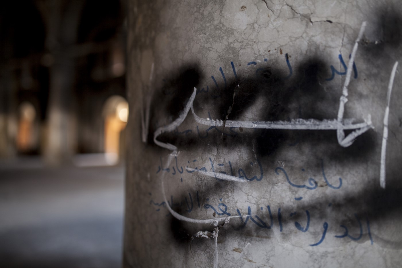 Arabic script drawn by ISIS members on one of the pillars inside the Kanesa Altaherea Alkbra church: "(...) The Islamic State remains because it’s got blood" The church was occupied and then burned by the Daesh in 2016. Qaraqosh - Hamdania - Mosul , Iraq. April 17, 2017