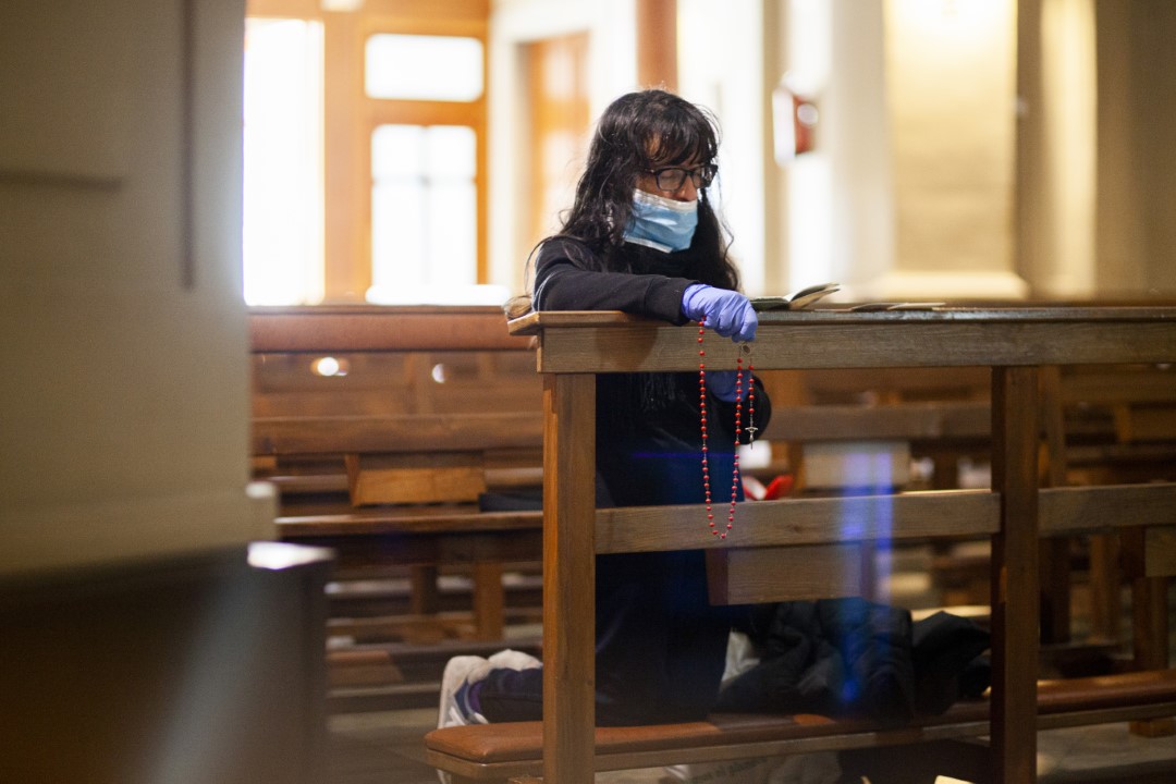 A Christian woman, protected with gloves and a mask, prays the rosary inside a church in the midst of the COVID-19 crisis. March 26, 2020; Sabadell, Barcelona.